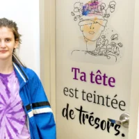 Des élèves devant une porte avec un slogan collé dessus