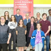 Des élèves avec leur enseignante au bas des escaliers du puits du hall