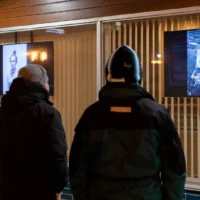 Des gens qui regardent la nouvelle expo urbaine dans le centre-ville de Matane en soirée