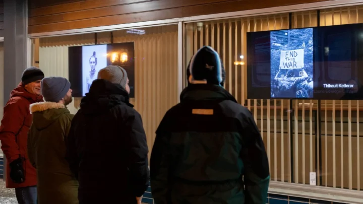 Des gens qui regardent la nouvelle expo urbaine dans le centre-ville de Matane en soirée