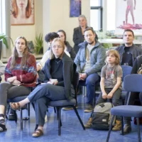 Des gens qui assistent à un exposition d'un projet en photographie à la bibliothèque