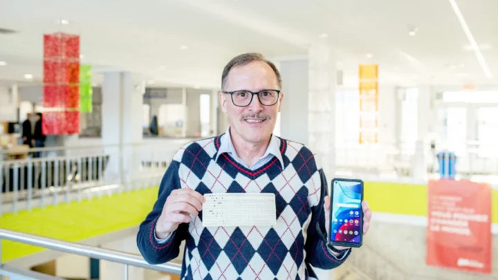 Photo de Réal Gendron avec ses premières cartes perforées et son téléphone intelligent, après 35 ans.