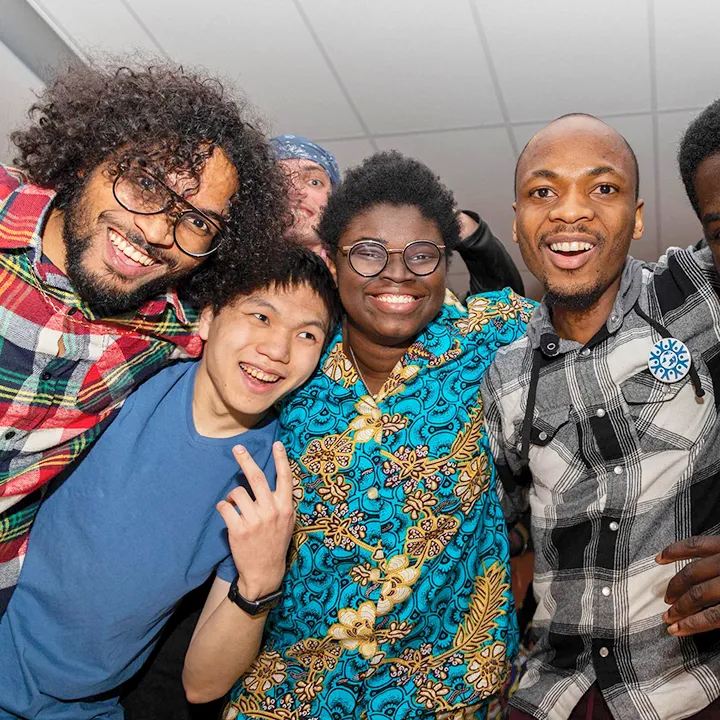 Des étudiantes et étudiants, le sourire aux lèvres, membres du comité local de l'EUMC, prennent un autoportrait lors d'un événement organisé par le comité.