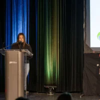 La directrice adjointe de l’école Zénon-Soucy, Anne Rouleau, prend la parole sur la scène de l'auditorium, en compagnie de l'enseignante en littérature Mylène Fortin, un micro à la main.