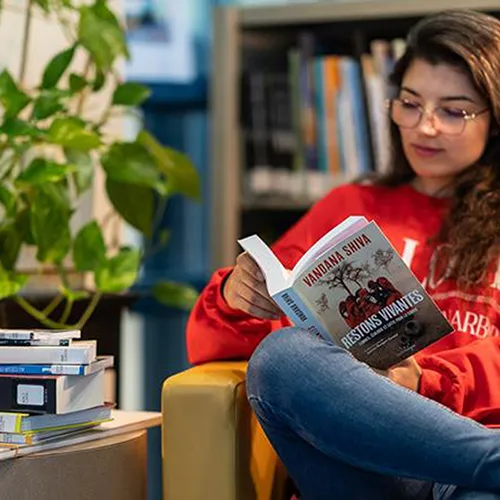 Une étudiante qui fait de la lecture à la bibliothèque.